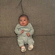 Asher is registered to the contest to win money with this photo: baby, infant, child, calvin_klein, clothing, socks, couch, sofa, seated, indoor, face, portrait, cute, young, person, expression, looking, home, furniture, texture