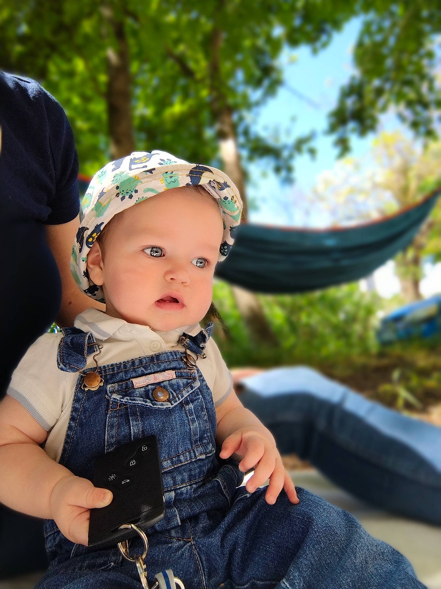 Mattéo a rejoint le concours — aidez-le/la à gagner de superbes lots ! baby, baby_toddler_clothing, cap, child, fashion_accessory, flash_photography, fun, grass, happy, hat, jewellery, pattern, person, plant, sitting, sleeve, sun_hat, toddler, tree, trunk