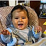 baby, high_chair, smile, happy, child, food, feeding, indoor, person, clothing, seat_belt, table, messy, cute, young_child, face, hand, sweater, meal, fun