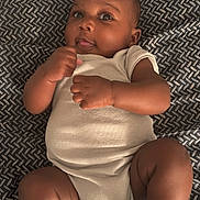 Tremeire joined the competition — help win amazing prizes! baby, infant, onesie, lying_down, blanket, patterned_blanket, curious_expression, chubby_cheeks, barefoot, indoor, cute, child, skin, face, head, limbs, newborn, person, soft_texture, cozy