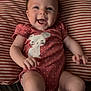 baby, infant, smiling, onesie, pink, polka_dot, bunny, pillow, striped, cute, happy, child, lying_down, home, indoor, face, arms, legs, soft, cozy