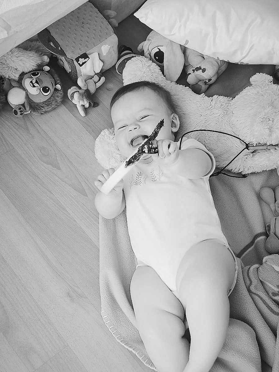 Léonnah participe au concours pour gagner de l'argent avec cette photo : baby, smiling, toy, blanket, plush_toy, floor, infant, happy, child, indoor, cushion, cute, playtime, lying_down, clothing, person, head, hand, foot, expression
