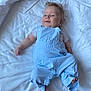 Lino a rejoint le concours — aidez-le/la à gagner de superbes lots ! baby, infant, child, blue_overalls, white_bed, smile, face, feet, lying_down, soft_light, cute, clothing, happy, skin, hair, one_person, indoors, portrait, relaxing, playful