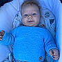 baby, blue_sweater, infant, face, eyes, knitted_clothing, bassinet, blanket, striped_shirt, cute, child, lying_down, smile, comfort, soft_toys, animal_prints, hand, fingers, young_child, portrait