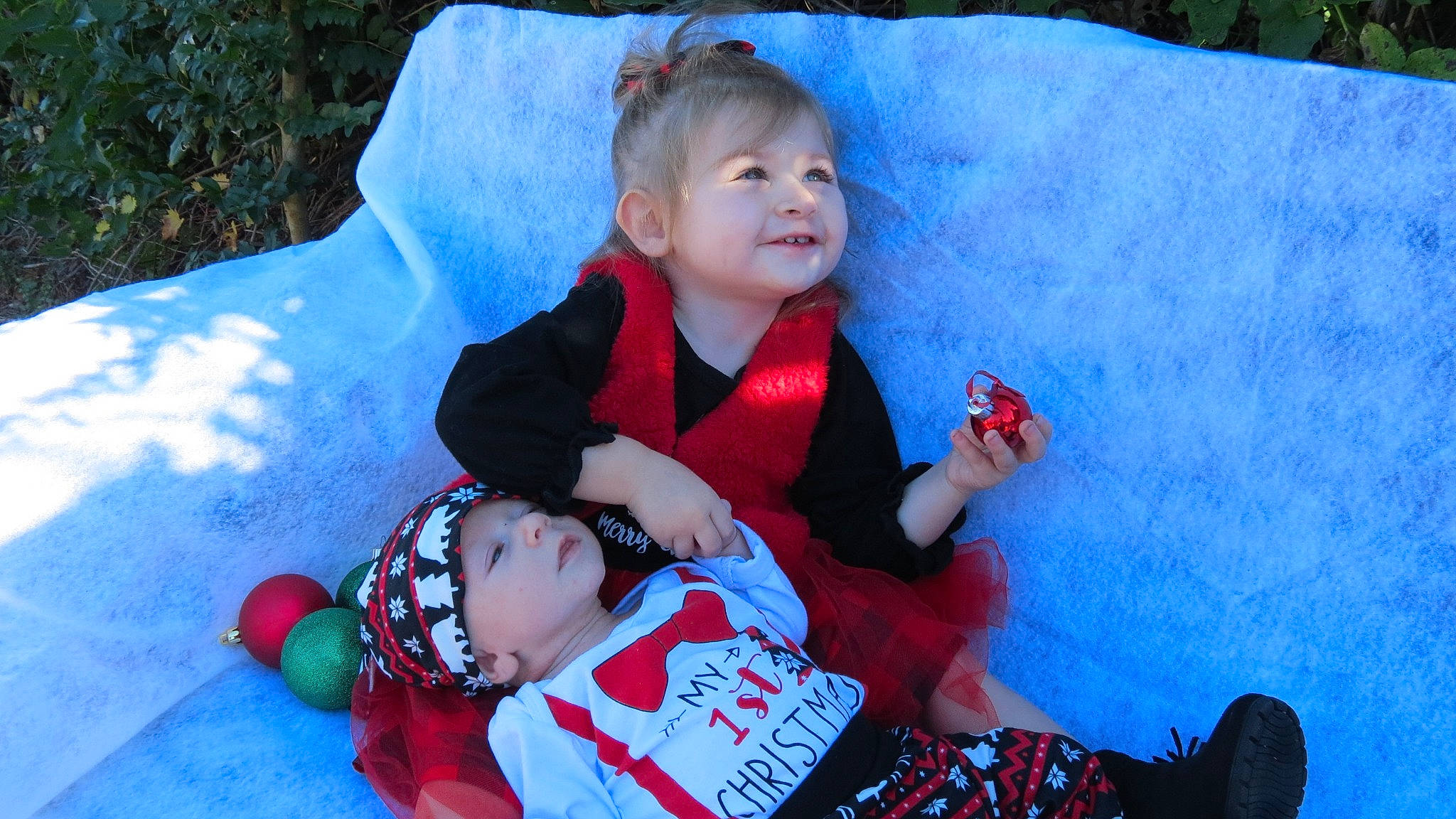 Maeve is registered to the contest to win money with this photo: azure, baby, baby_toddler_clothing, eye, face, fun, grass, happy, head, headwear, human_body, leaf, leisure, organ, people, person, pink, red, skin, textile