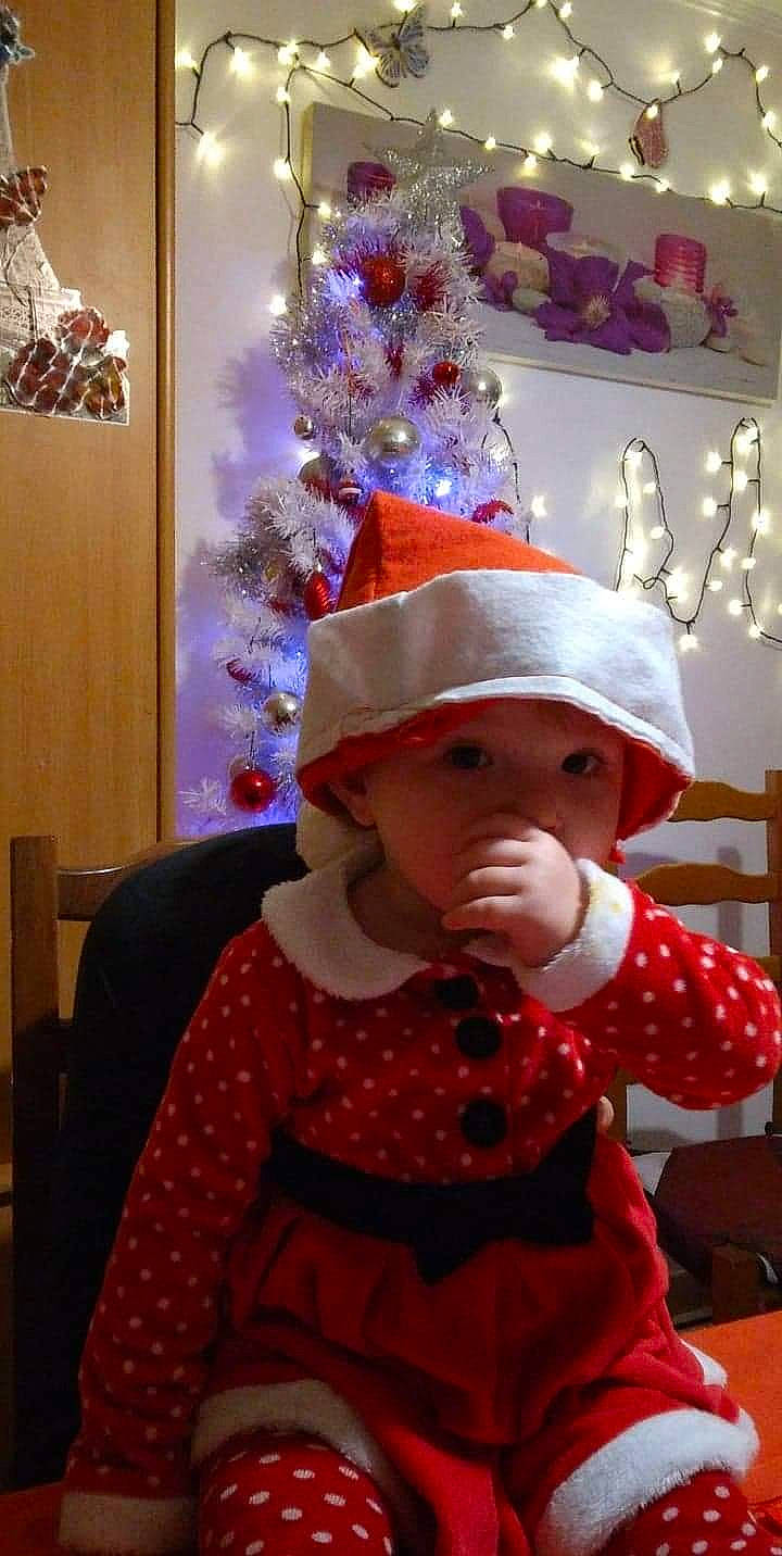 Laurine participe au concours pour gagner de l'argent avec cette photo : baby_toddler_clothing, child, christmas, christmas_decoration, christmas_eve, christmas_ornament, christmas_tree, costume_hat, event, hat, headwear, holiday, holiday_ornament, one_piece_garment, ornament, party_supply, pattern, person, pink, sleeve