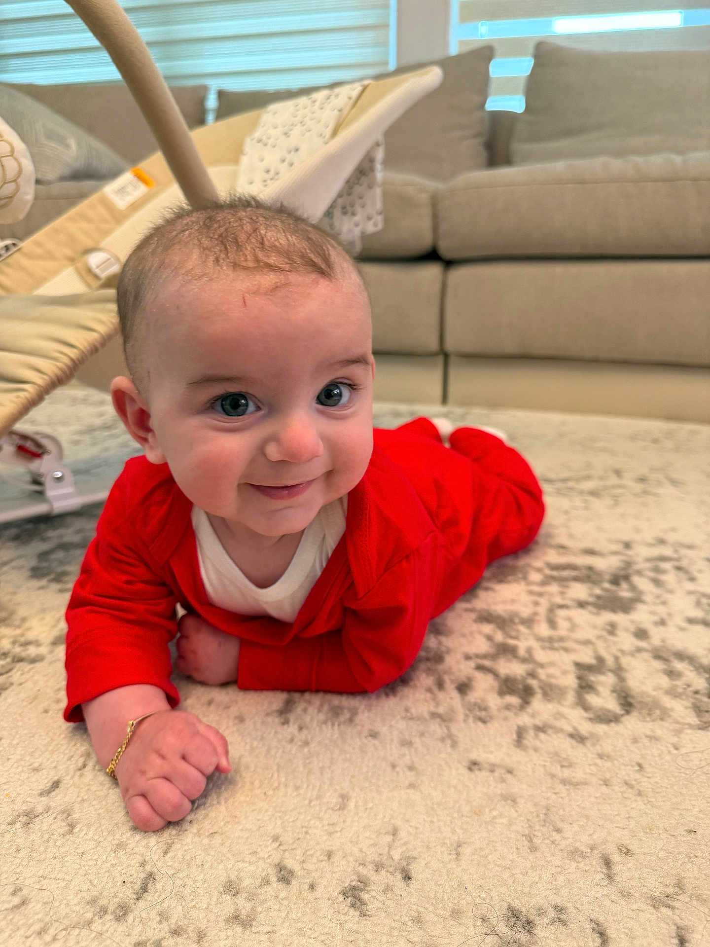 Giovanni joined the competition — help win amazing prizes! baby, infant, red_clothing, bracelet, carpet, floor, smile, face, indoor, couch, furniture, baby_gear, happy, child, person, home, cute, lying_down, young, bright
