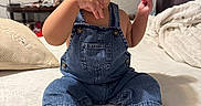 Luka joined the competition — help win amazing prizes! baby, child, toddler, denim_overalls, shoes, smiling, happy, indoors, bed, blanket, pillow, person, cute, sitting, expression, face, clothing, footwear, home, cozy