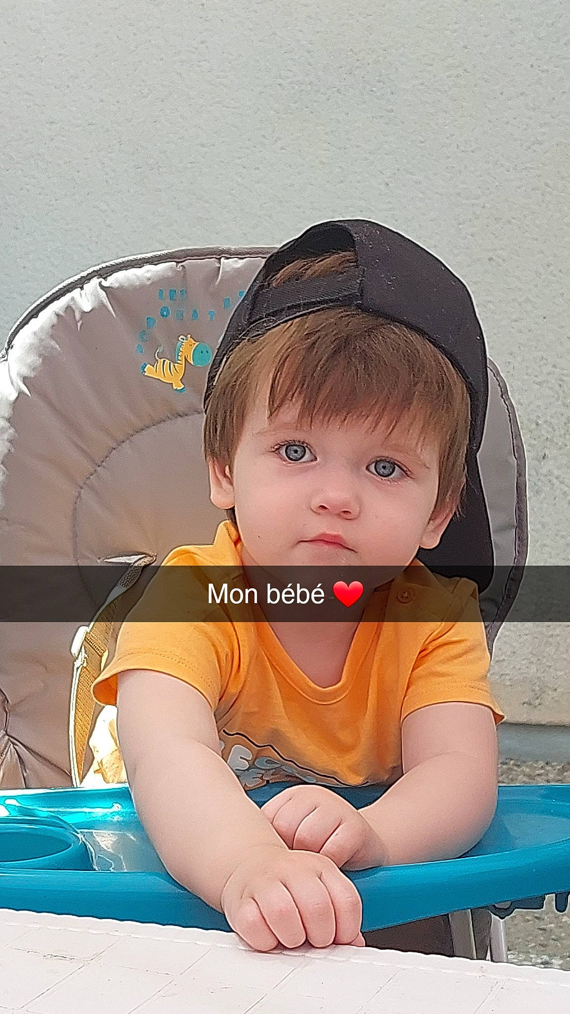 Liaam participe au concours pour gagner de l'argent avec cette photo : auto_part, bangs, black_hair, child, electric_blue, fashion_accessory, flash_photography, fun, hairstyle, happy, human_body, leisure, person, recreation, sitting, skin, sleeve, t_shirt, toddler, umbrella