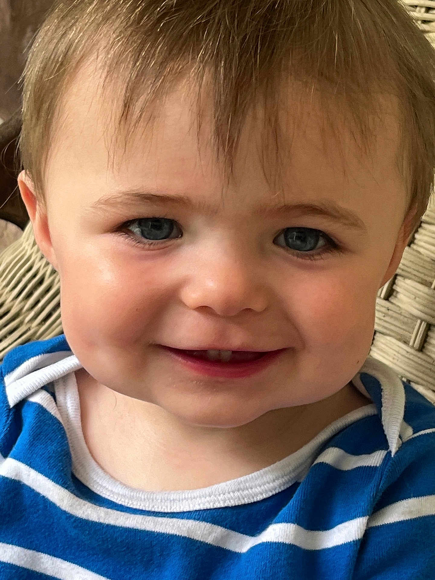 Bennett is registered to the contest to win money with this photo: toddler, child, face, blue_eyes, smile, striped_shirt, clothing, person, portrait, close_up, baby, hair, skin, chair, woven_chair, happy, indoors, young_child, cute, head