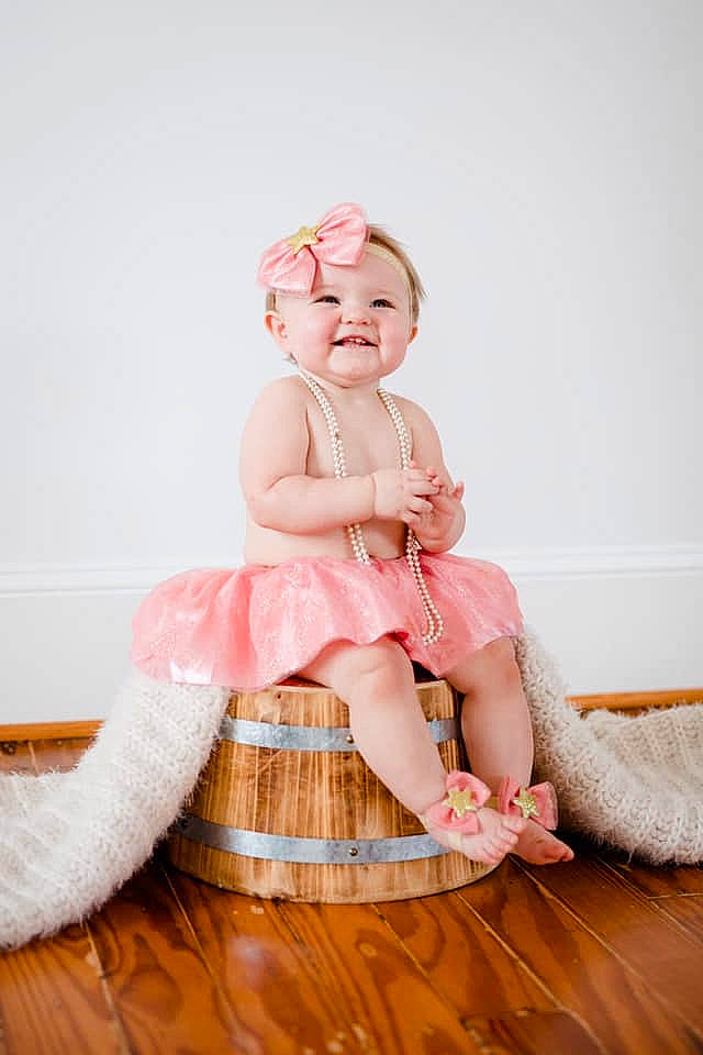 Hadley is registered to the contest to win money with this photo: baby, beauty, child, child_model, costume, fashion_accessory, footwear, hair_accessory, happy, headgear, headwear, joy, leg, peach, person, photograph, photography, pink, product, shoe
