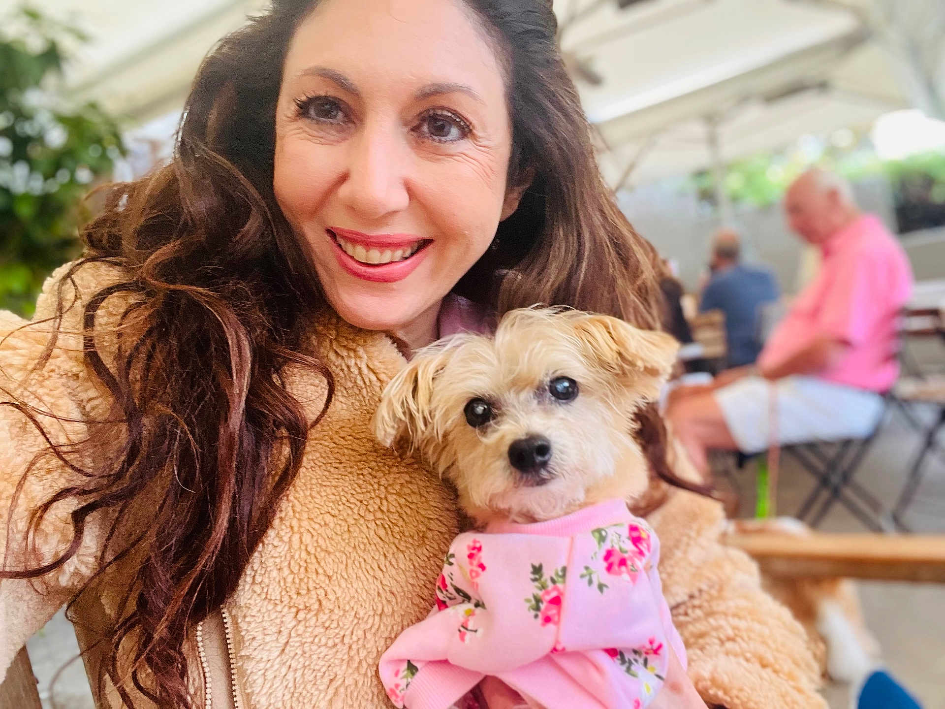 Princess joined the competition — help win amazing prizes! woman, dog, pet, smile, portrait, cozy_clothing, fleece_jacket, pink_outfit, floral_pattern, long_hair, outdoor, cafe, table, chair, people, blurred_background, happy, face, small_dog, casual