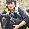 Hathyr participe au concours pour gagner de l'argent avec cette photo : animal, backpack, black_dog, candid, casual, companion, dog, fur, greenery, hand, jacket, nature, outdoor, person, pet, portrait, sitting, stone_wall, tail, yellow_hood