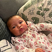 Mabel joined the competition — help win amazing prizes! baby, infant, face, pout, couch, cushion, floral_clothing, pattern, hand, skin, cute, indoors, comfort, child, young, portrait, expression, sleeve, closeup, relaxing