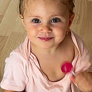 Agatha participe au concours pour gagner de l'argent avec cette photo : toddler, child, smiling, pacifier, lollipop, pink_shirt, leopard_print_pants, earrings, hair_tie, indoor, wooden_floor, cute, playful, portrait, baby, person, holding, small_child, happy, young