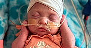 Eloise is registered to the contest to win money with this photo: baby, blanket, child, closeup, cute, face, flower, hands, headband, hospital, infant, medical_tubes, newborn, peaceful, peach_outfit, resting, seashell_embroidery, skin, sleeping, soft
