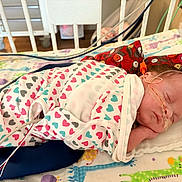 Eloise joined the competition — help win amazing prizes! baby, bed, blanket, child, crib, cute, face, giraffe_pattern, healthcare, heart_pattern, hospital, indoor, infant, medical_tubes, newborn, onesie, person, pillow, resting, sleeping