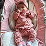 baby, infant, pacifier, pink_clothing, headband, baby_seat, carpet, indoors, cute, child, plush, soft_texture, relaxing, portrait, small_person, sock, cozy, baby_girl, comfort, wearing