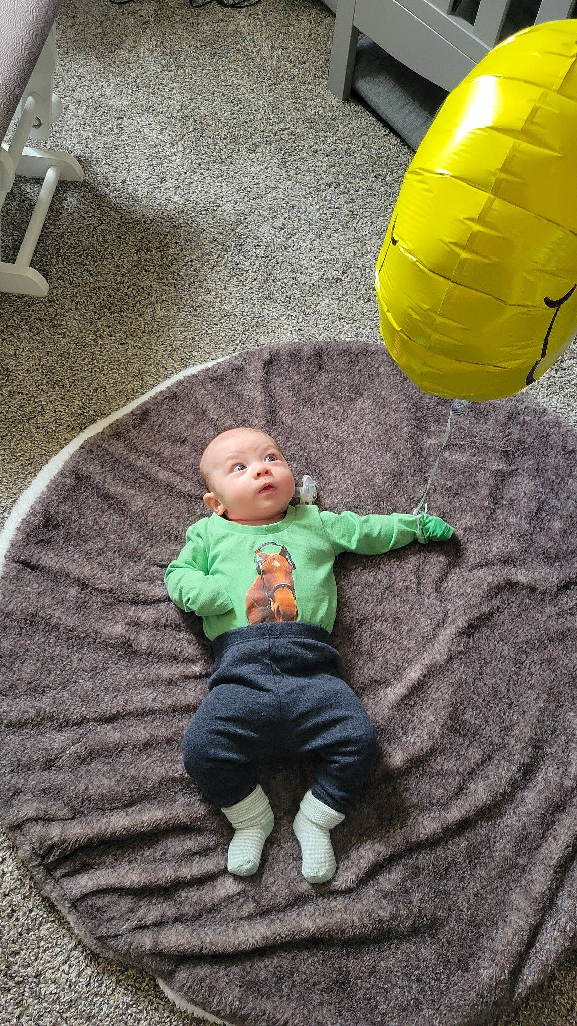 Clarissa is registered to the contest to win money with this photo: asphalt, automotive_tire, baby_toddler_clothing, ball, child, comfort, floor, flooring, fun, grass, leisure, person, play, public_space, road_surface, sitting, standing, toddler, toy, white