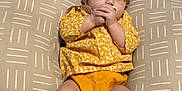 Hadley joined the competition — help win amazing prizes! baby, child, infant, yellow_clothing, headband, pillow, blanket, bed, footwear, leopard_print, socks, indoors, resting, cute, patterned, comfort, soft_furnishing, sleepwear, person, portrait