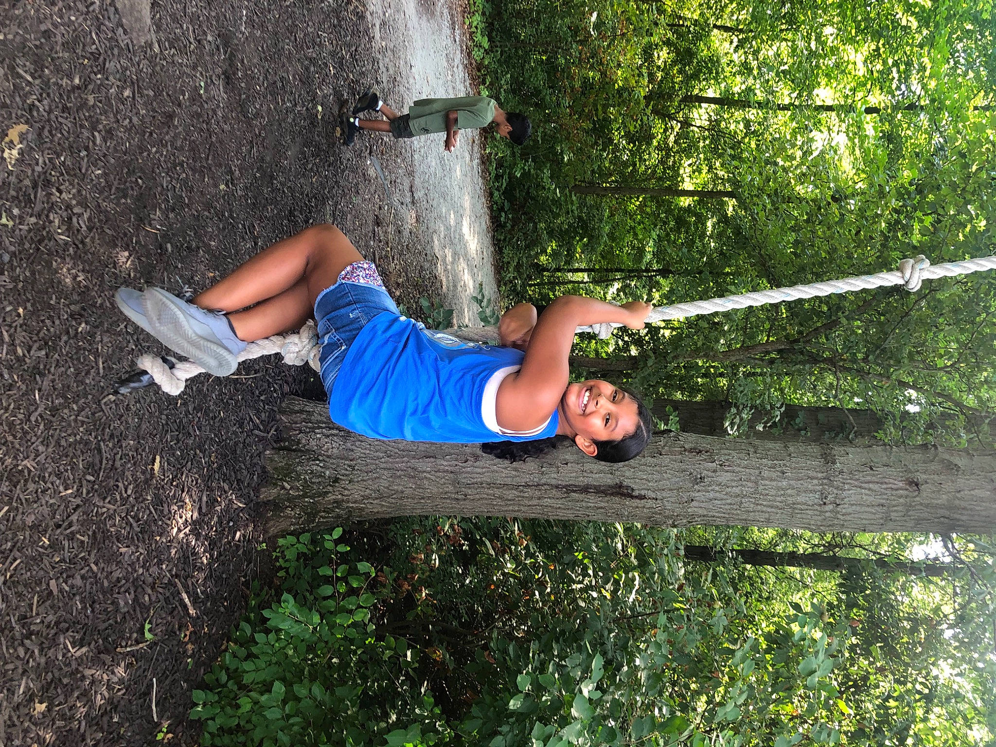 Tianna is registered to the contest to win money with this photo: adventure, elbow, electric_blue, forest, fun, grass, green, happy, joy, jungle, landscape, leisure, people_in_nature, person, plant, recreation, rope, shorts, shrub, soil