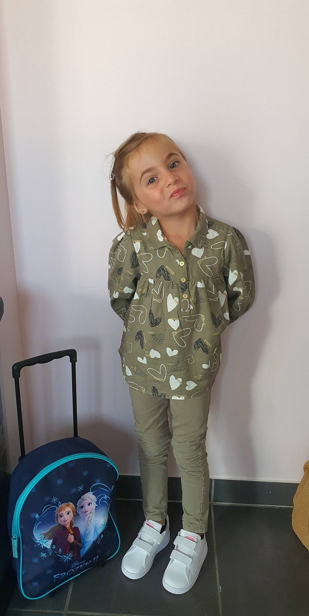 Chiara participe au concours pour gagner de l'argent avec cette photo : baby_toddler_clothing, bag, blond, child, electric_blue, fashion_accessory, fashion_design, fun, hair, head, human_leg, knee, pattern, person, personal_protective_equipment, room, sitting, sleeve, smile, thigh