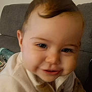 Eileen participe au concours pour gagner de l'argent avec cette photo : apparel, baby, child, clothing, couch, cozy, cute, expression, eyebrows, face, hair, head, home, indoor, infant, person, portrait, sitting, smile, young