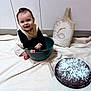 Emy a rejoint le concours — aidez-le/la à gagner de superbes lots ! baby, baking, blanket, bowl, cabinet, cake, child, cooking, cute, floor, flour, happy, indoor, kitchen, person, powdered_sugar, sitting, smiling, whisk, wooden_board