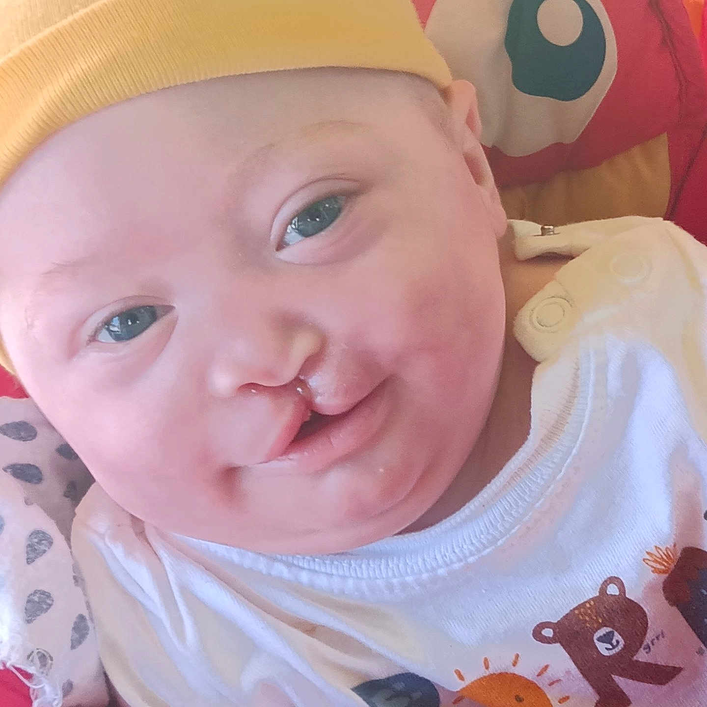 Elijah is registered to the contest to win money with this photo: baby, baseballcap, bodypart, cap, clothing, cushion, face, happy, hat, head, homedecor, laughing, mouth, person, photography, portrait, selfie, smile, t_shirt, teeth