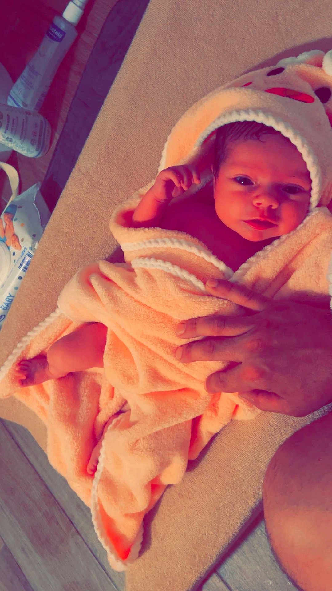 Valentina participe au concours pour gagner de l'argent avec cette photo : baby, towel, infant, hand, face, skin, blanket, hooded_towel, floor, person, newborn, curious, soft_texture, baby_care, wipes, lotion, home, closeup, wrapped, cute