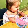 Chesney joined the competition — help win amazing prizes! toddler, child, smiling, bow, hair_accessory, table, snacks, sippy_cup, pink, blue, green_wall, wood, chair, happy, cute, indoors, person, food, playing, casual