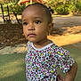 casual, child, curly_hair, cute, daylight, expression, heart_pattern, nature, outdoor, pattern, person, playground, portrait, shirt, standing, summer, sunlight, toddler, trees, young