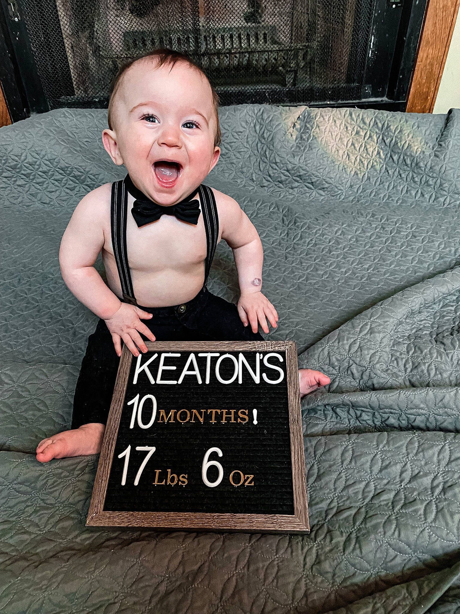 Keaton is registered to the contest to win money with this photo: baby, baby_toddler_clothing, black, cool, couch, eye, facial_expression, flash_photography, floor, flooring, grey, hand, happy, human, person, product, sleeve, smile, t_shirt, textile