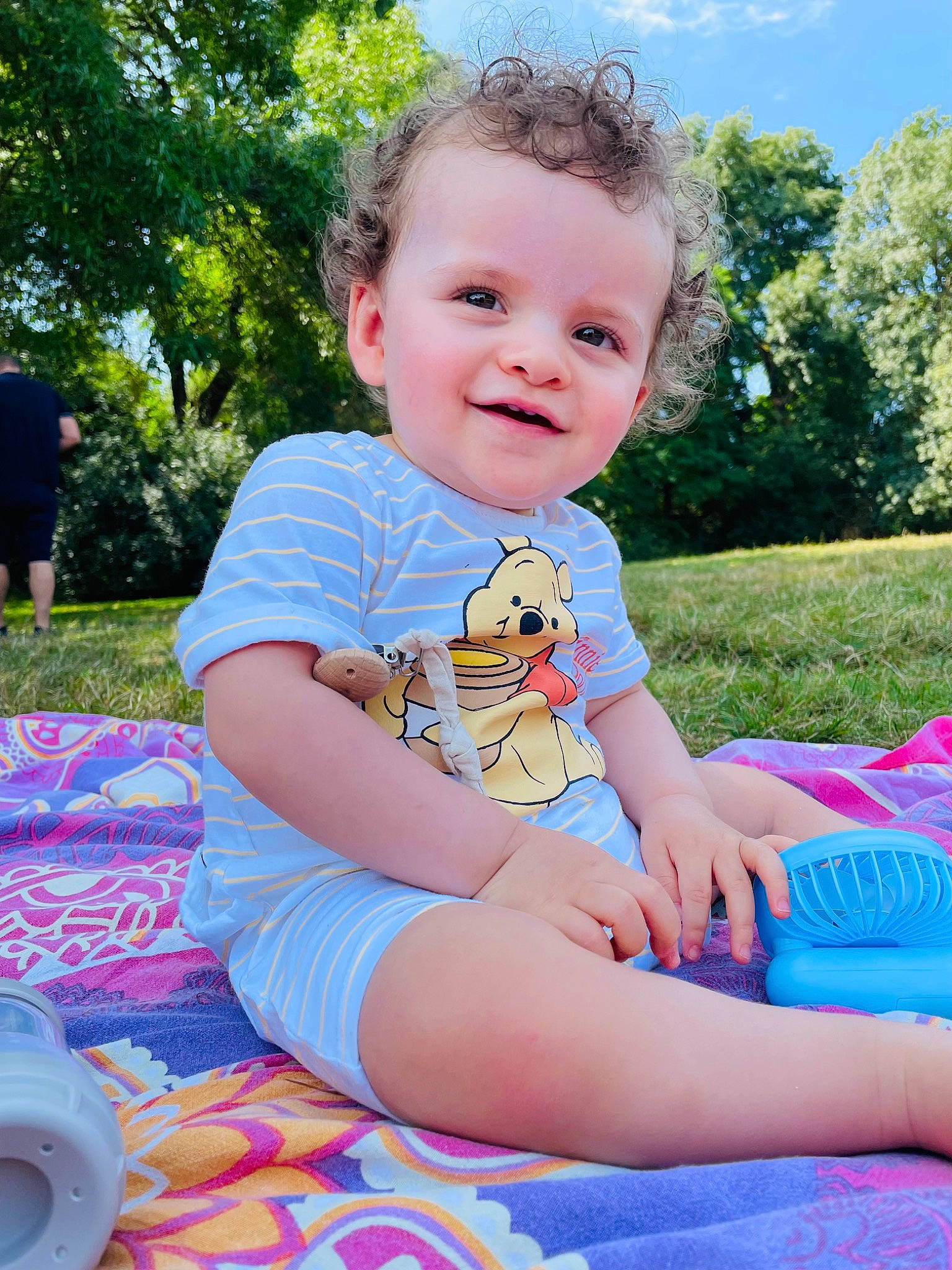 Nahïm a rejoint le concours — aidez-le/la à gagner de superbes lots ! baby_toddler_clothing, child, electric_blue, fun, grass, happy, joy, lap, leisure, people_in_nature, person, pink, plant, public_space, recreation, sitting, sky, smile, sunlight, thigh