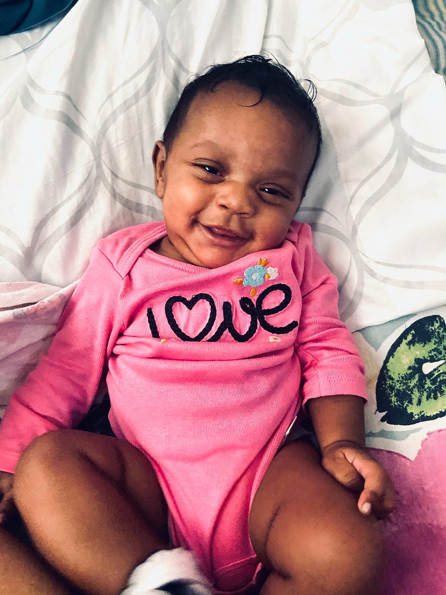 Unity is registered to the contest to win money with this photo: arm, baby, baby_toddler_clothing, cheek, comfort, eye, facial_expression, finger, hairstyle, happy, joy, leg, mouth, person, pink, product, skin, sleeve, smile, textile