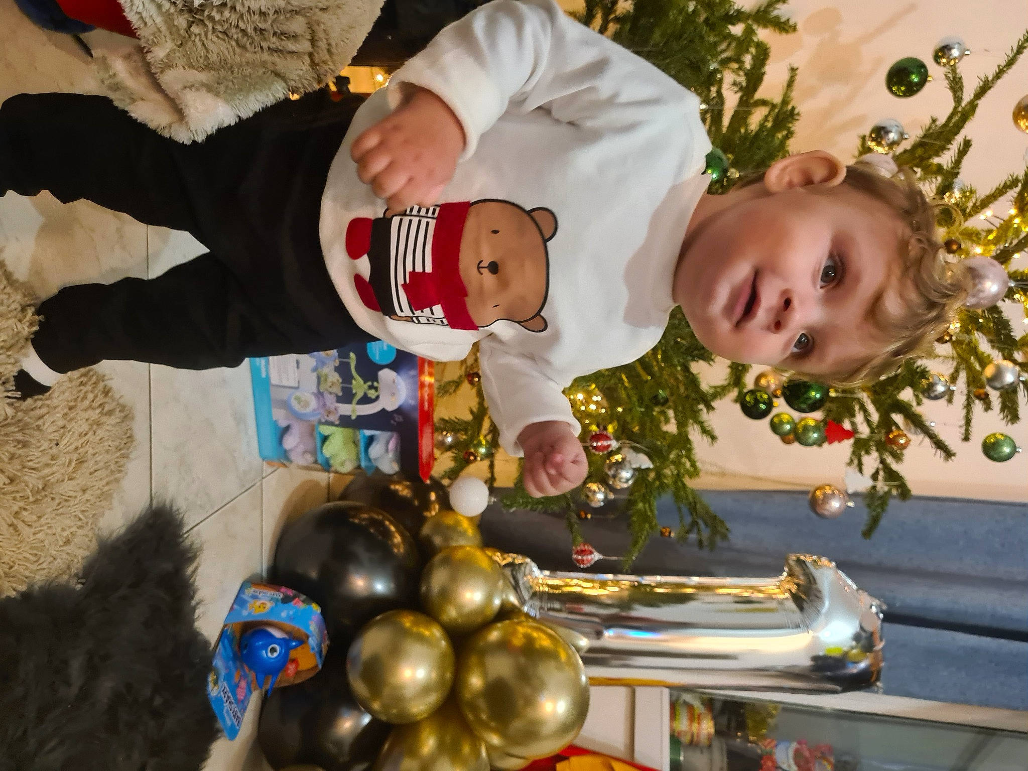 Sebastian participe au concours pour gagner de l'argent avec cette photo : baby, brass_instrument, child, christmas, christmas_decoration, christmas_eve, christmas_ornament, event, fun, happy, hat, holiday, human, person, plant, smile, snapshot, toddler, tradition, tree