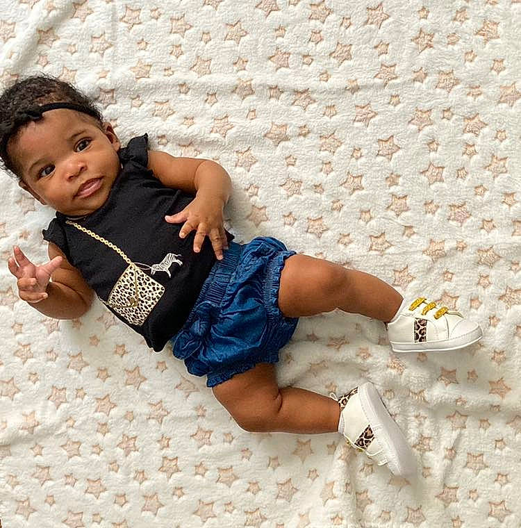 Kilani is registered to the contest to win money with this photo: baby_toddler_clothing, barefoot, child, comfort, finger, flooring, foot, hand, human_leg, knee, leg, linens, pattern, person, skin, sleeve, sock, t_shirt, thigh, waist