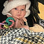 baby, infant, child, stroller, car_seat, fuzzy_hat, blanket, teething_toy, teether, pink_clothing, blue_eyes, chubby_cheeks, closeup, portrait, cozy, warm, sitting, soft_toy, houndstooth_blanket, accessory