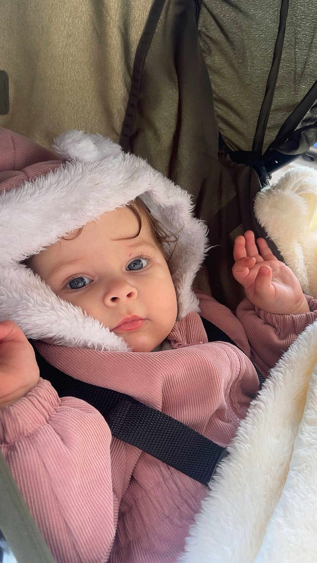 Aïcha a rejoint le concours — aidez-le/la à gagner de superbes lots ! baby, infant, child, blue_eyes, fur_hood, hood, pink_jacket, blanket, stroller, car_seat, safety_belt, hand, cozy, close_up, portrait, eyelashes, soft_texture, winter_clothing, curious_expression, seat_fabric