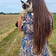 Utopia participe au concours pour gagner de l'argent avec cette photo : person, cat, long_hair, blue_eyes, patterned_dress, field, grass, path, outdoor, cloudy_sky, nature, animal, pet, holding, back_view, fur, ears, rural, summer, scenic