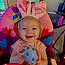 Koura is registered to the contest to win money with this photo: toddler, child, bunny_ears, high_chair, toy, egg, polka_dot, smiling, happy, indoor, colorful, pink, blue, heart_pattern, furniture, person, cute, playful, portrait, baby