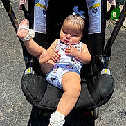 Valenciannah is registered to the contest to win money with this photo: baby, child, stroller, onesie, flower, anklet, footwear, sunlight, outdoor, asphalt, person, infant, cute, relaxed, clothing, headband, skin, hand, legs, babywear