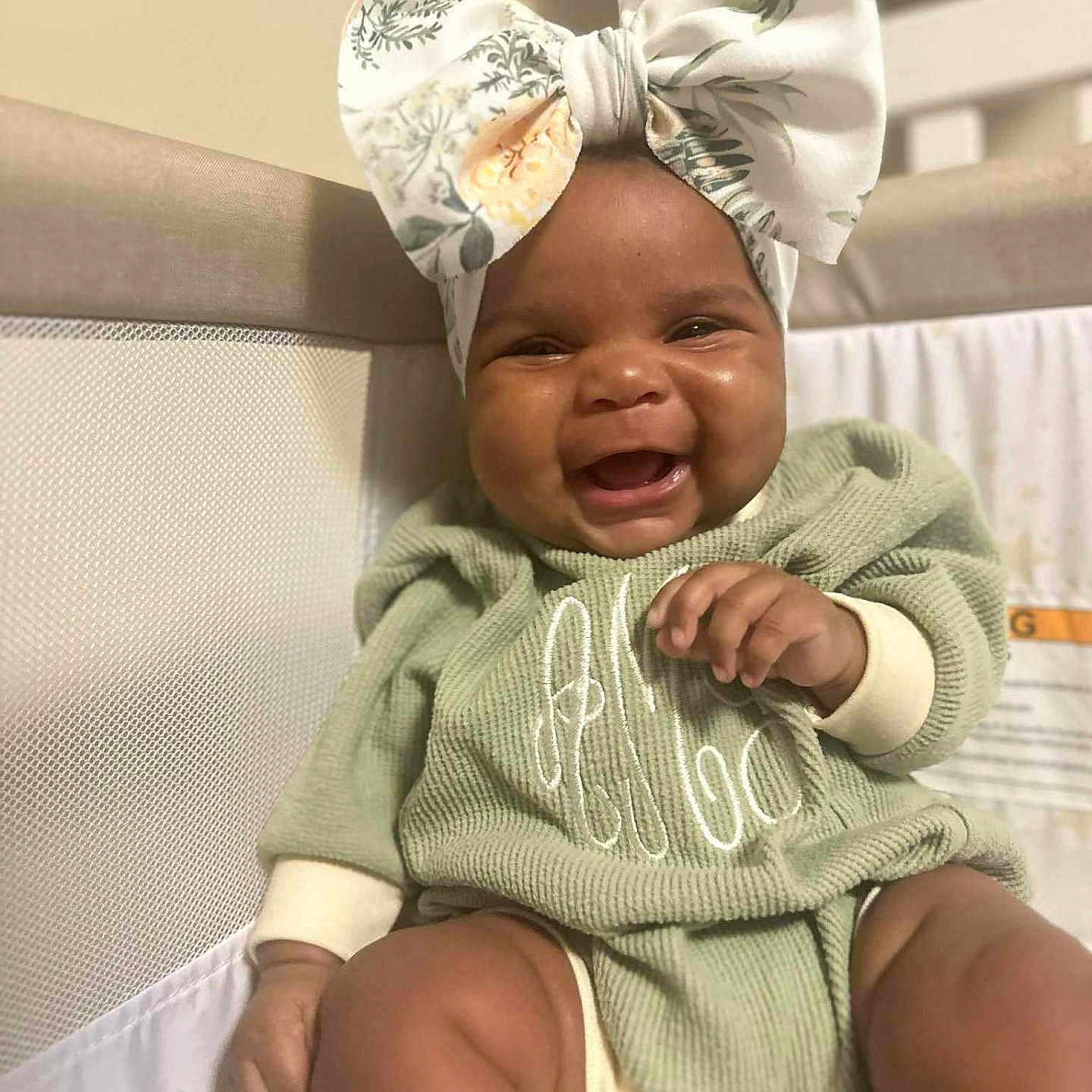 Anna-Lisa is registered to the contest to win money with this photo: baby, baby_clothes, bow, child, cozy, crib, cute, fabric, face, green_clothing, hand, happy, headwear, indoors, infant, legs, portrait, sitting, skin, smiling