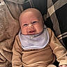 baby, smiling, face, bib, clothing, blanket, cushion, pattern, infant, cute, cozy, portrait, happy, soft, indoor, child, person, toddler, warm, comfort