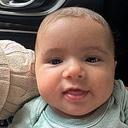 Bryan is registered to the contest to win money with this photo: baby, child, face, smile, clothing, mint_green, sitting, indoor, car_interior, door_handle, knitted_sleeve, young_child, portrait, cute, happy, person, head, hand, casual_wear, infant