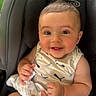 baby, infant, car_seat, smiling, happy, child, hand, ring, clothing, fabric, seat, indoor, person, cute, skin, face, eyes, mouth, fingers, comfort