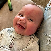 Kayson is registered to the contest to win money with this photo: baby, smiling, infant, face, onesie, clothing, couch, fabric, jeans, ripped_jeans, happy, cute, skin, cheeks, indoor, person, portrait, closeup, comfort, cozy