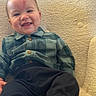 Kayson is registered to the contest to win money with this photo: baby, child, smiling, plaid_shirt, pants, barefoot, indoor, soft_surface, happy, cute, portrait, infant, face, head, skin, clothing, comfort, relaxed, young, person