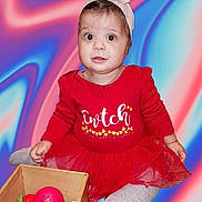 Laila is registered to the contest to win money with this photo: baby, child, girl, headband, flower, red_dress, tutu, toy, wooden_box, fruit, vegetables, sitting, colorful, play, indoors, portrait, cute, expression, background, knitted_tights