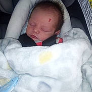 Adam is registered to the contest to win money with this photo: newborn, baby, sleeping, blanket, car_seat, pacifier, infant, face, child, cozy, indoor, resting, soft, cute, bundle, portrait, person, clothing, screenshot, mobile_screen